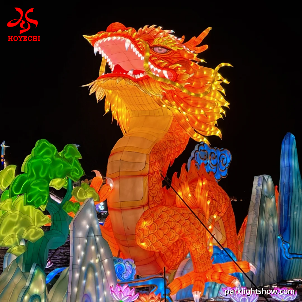 Large outdoor dragon lantern with illuminated scales and mountain scenery for a public festival