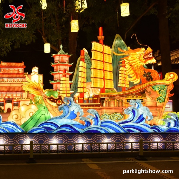 Illuminated dragon boat lantern with sails and ocean waves at a night lantern festival packlightshow