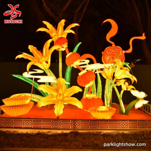 Giant lily flower lanterns with hanging red lanterns in an outdoor night display packlightshow