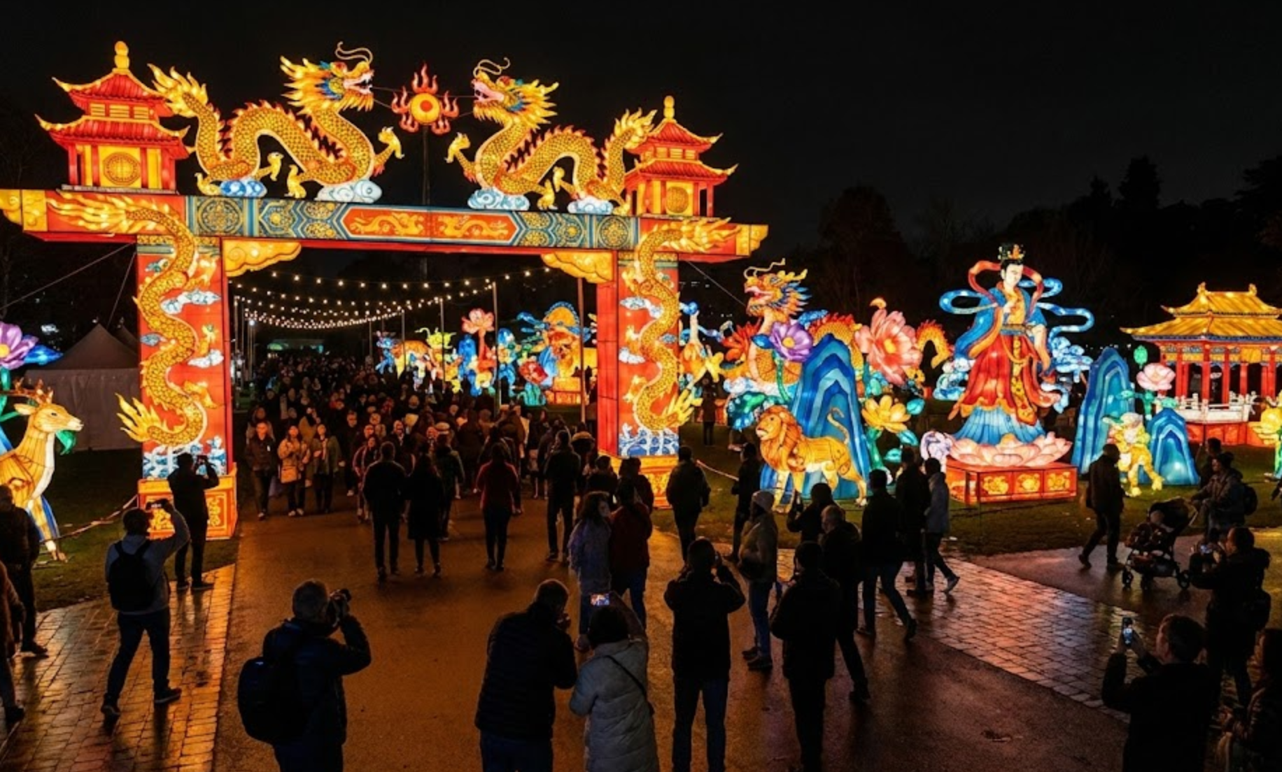 Chinese Lantern Festival entrance gate with dragon lantern arch and large illuminated displays in a park at night