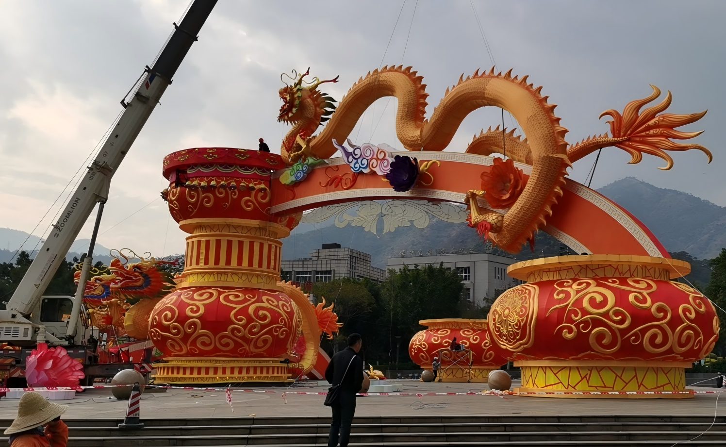 Giant Dragon Lantern On-Site Installation Installation crew using lifting equipment to assemble a giant dragon lantern for an outdoor festival