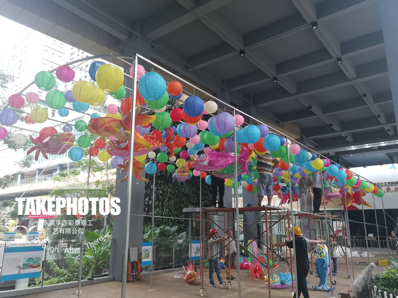On-site assembly of a suspended fish and round lantern display by the project team