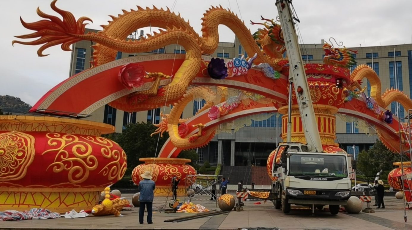 HOYECHI team installing a large custom dragon lantern structure with crane support at an outdoor project site
