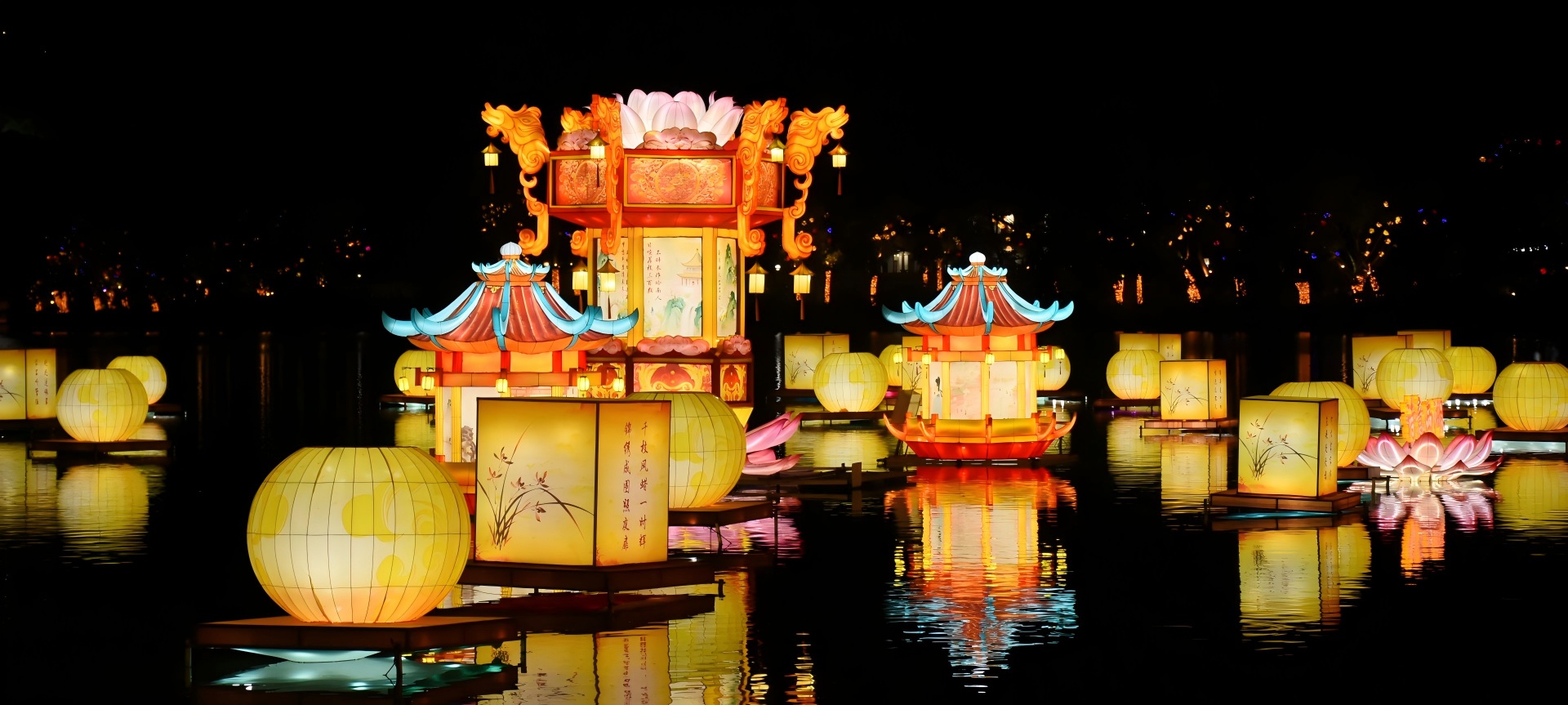 Traditional Chinese pavilion and lotus lantern installations reflected on water at a nighttime China Light Festival