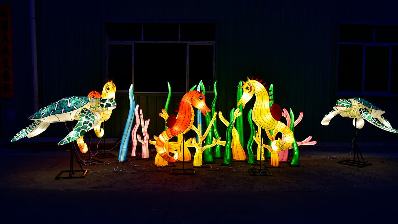 Illuminated sea turtles and seahorses arranged with coral and seagrass lanterns
